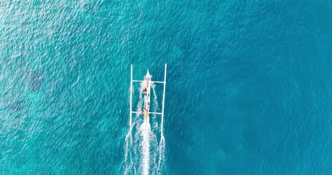 Top Down Drone View of Traditional Jukung Boat on Turquoise Ocean in Bali Stock Footage 334807774