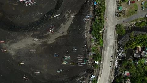 Top-down drone view of traditional fishing boats resting on volcanic black sand Video stock 337885797