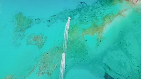 Top down drone view of two speedboats leaving white foam trails on crystal .. Stock Photos