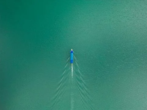 Top Down Drone View of Vertical Boat Moving Upward on Lake Albania Stock Photos