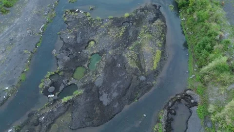 Top down drone view of volcanic riverbed with emerald pools and flowing stream Video stock 337795030