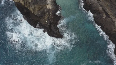 Top down drone view of waves crashing into big dark rocky cliffs, Hawaii Stock Footage 126605115