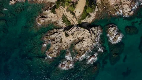 Top-down drone view of waves crashing on rocky cape Stock Footage 321346120