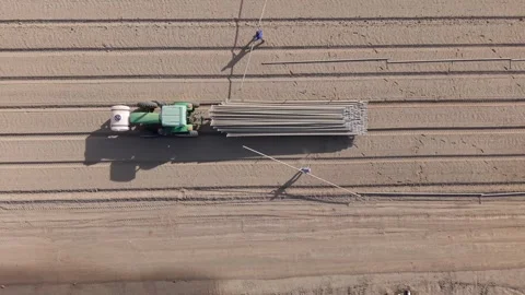 Top Down Drown Shot Of Farmers Laying Down Water Irrigation System Pipes Off A Stock Footage 304309036