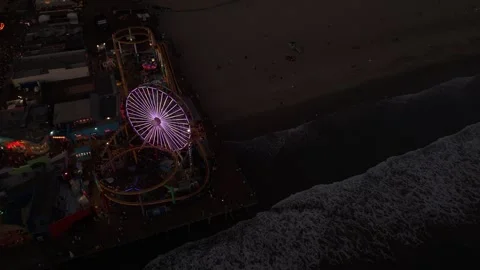 Top-Down Dusk Flyover Above Purple Ferris Wheel, Pier and Breaking Surf Vídeos de archivo 342759013