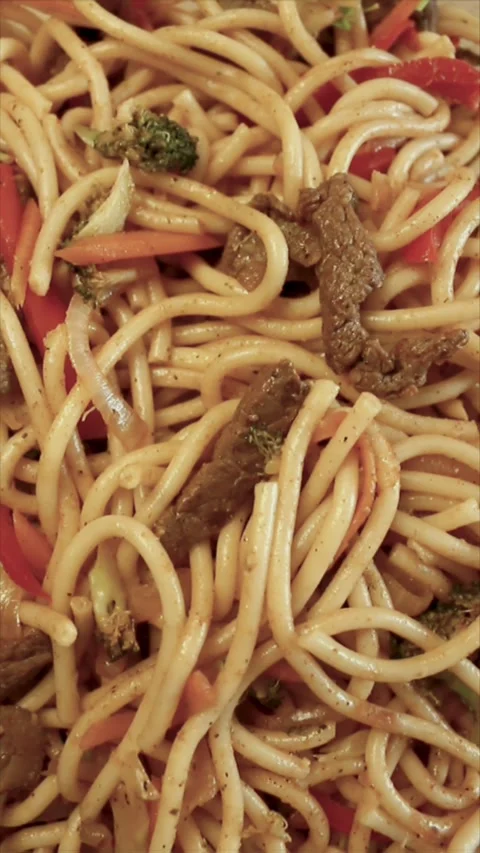 Top-down, dynamic close-up shot of a tray with fried noodles. Stock Footage 303722450