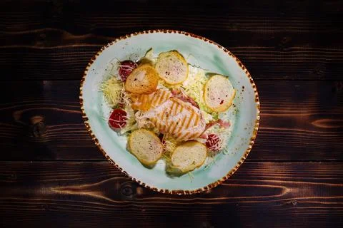 Top-down elevated view of a classic chicken Caesar salad served on a handmade Foto stock