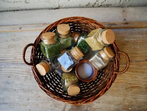 Top-Down Flat Lay of Glass Spice Jars with Cork Lids in a Round Wicker Basket Stock Photos