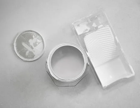 Top-down flat lay of an open paint can with white interior paint beside Fotos de archivo