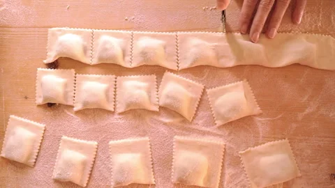 Top down flat lay view of 4k slow motion hands cutting the strip of filled .. Stock Footage 278232624