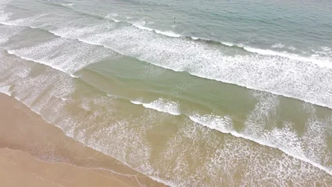 Top down fly shore to sea over surfers in playa de Oyambre, Cantabria, Spain 4K Video stock 155598907