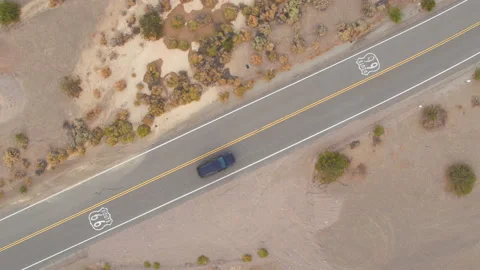 TOP DOWN: Flying above Route 66 as lone car drives along the straight highway Stock Footage 156422343