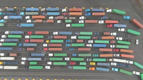 TOP DOWN: Flying above trucks driving between others waiting in the Port of LA. Stock Footage 118129248