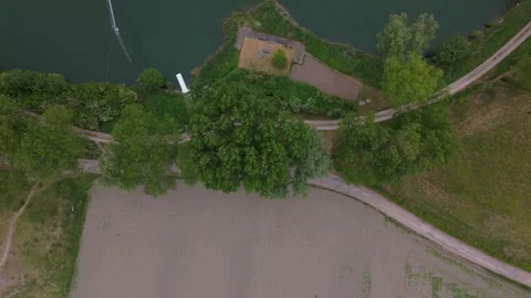 Top-Down Flyover from Fields to Lake Through Tree Line | FlyLens 4K Stockbeeldmateriaal 309205669