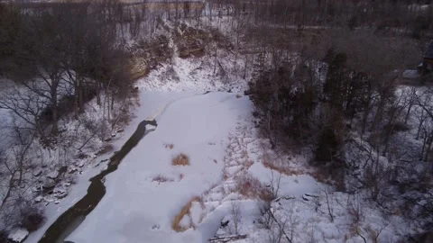 Top down flyover of a frozen river revealing a waterfall Stock Footage 228467558