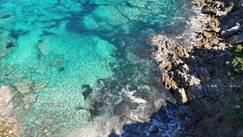 Top-Down Forward Drone Flight Toward Rocky Coast with Turquoise Water in Stock Footage 332266311