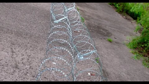 Top-Down Forward Track Along Paired Concertina Wire Coils Stock-Footage 344122817