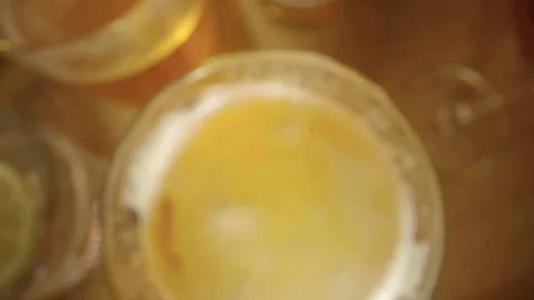 Top-down forward tracking into glass with yellow liquid Stock Footage 335704422