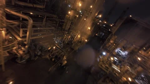 Top-down FPV drone speed plunge over refinery pipes and smoke during night Video stock 321600811