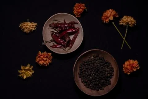 Top down image of black pepper and dried chili in a wooden bowl decorated wit Stock Photos