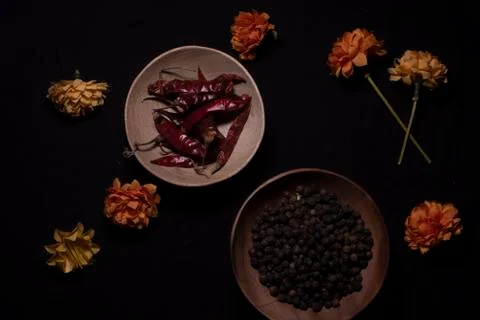 Top down image of black pepper and dried chili in a wooden bowl decorated wit Stock Photos