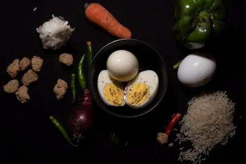 Top down image of a boiled eggs in a bowl decorated with cereals and vegetabl Stock Photos