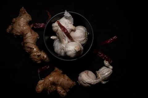 Top down image of collection of garlic and ginger in dark copy space backgrou Stock Photos