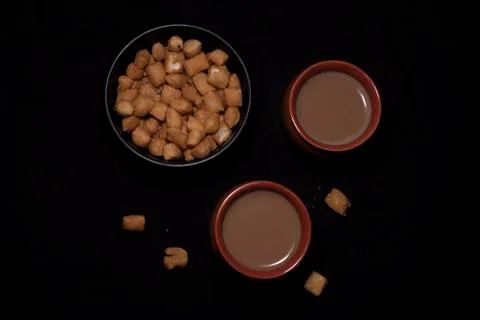 Top down image of infused tea in earthen cups along with a bowl of snacks kep Stock Photos