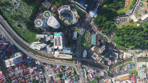 Top-down interchange and hotel district with pools beside cemetery in Kuala Stock Footage 327125120