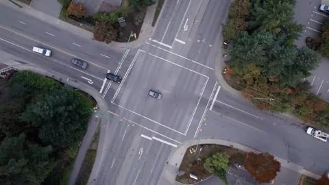 Top down of intersection with traffic lights and cars commuting. 4K 24FPS Stock Footage 251683233