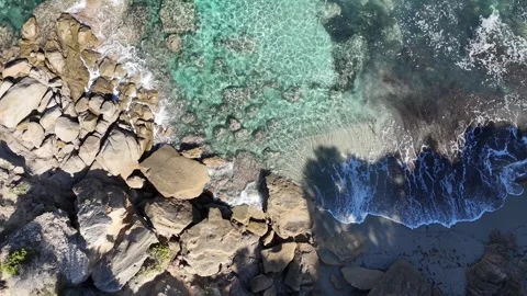 Top-Down Lateral Drone Flight Over Turquoise Beach and Rocks in Capo Tes Stock Footage 332266315