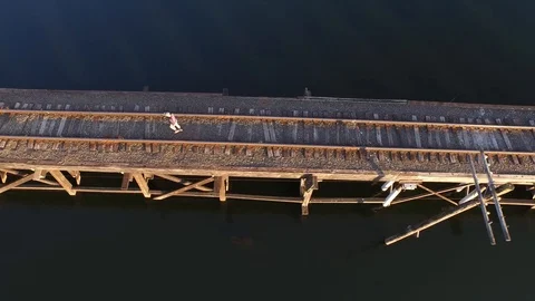 Top Down Man Walks Abandoned Train Tracks Bridge Lake, Washington Stock Footage 101625603