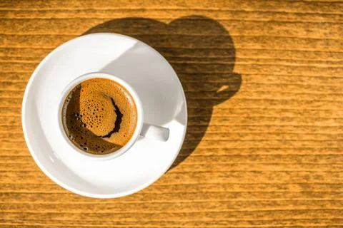 Top down morning creativity concept, smiled cup coffee with sunbeams, closeup 写真素材