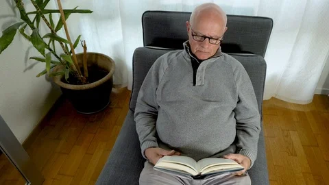 Top Down Motion Timelapse of Elderly Glasses Man Reading Book At Home Stock Footage 112698262