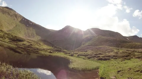 Top-down mountain glacial pond that reflects the sun Stock Footage 40699572