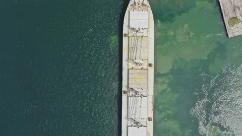 Top down moving forward drone shot massive dry cargo grain vessel leaves port Stock Footage 238695327