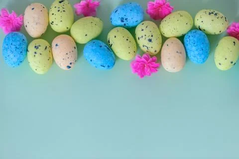 Top down of multi colored painted Easter eggs and spring flowers over blue ba Foto stock
