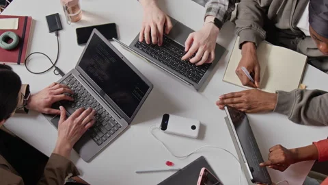 Top Down of Multiethnic Programmers Collaborating and Coding on Laptops Stock-Footage 336714055