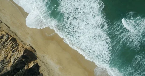Top down ocean beach rock cliffs rightward motion along cliffs on GH4 Stock Footage 99600176