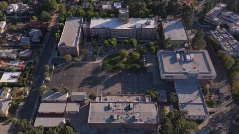 Top down orbit shot showcasing historic brick school building with clock tower, Stock Footage 336634863