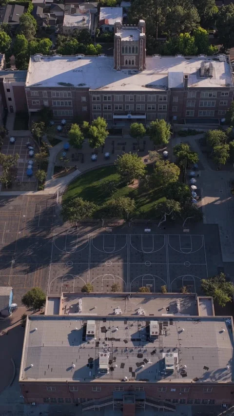 Top down orbit shot showcasing historic brick school building with clock tower, Stock Footage 337315956