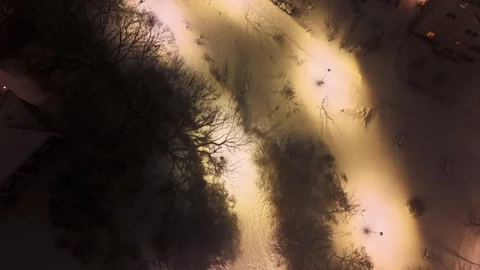 Top down over a lit park path in snow at night Video stock 349035815