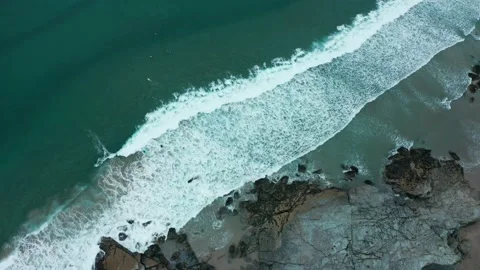 A top down, overhead aerial of waves crashing on rocks and surfers Stock Footage 137422407