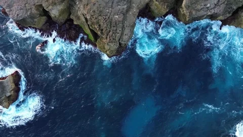 Top Down Overhead Drone View of Crashing Waves on Rocky Ocean Cliff Vídeos de archivo 345827234