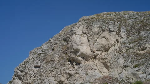 Top-Down Pan of Rocky Canyon Wall with Green and Yellow Grass Stock Footage 315849792
