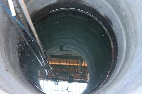 Top down perspective of deep circular dark stone well Stock Photos