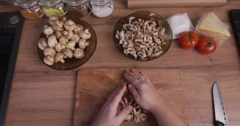 Top-down perspective of female hands on a wooden kitchen counter, gathering Stock Footage 329860833
