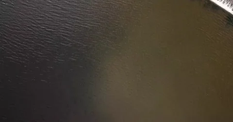 Top-down perspective of lake and weir dam at midday on a partly-cloudy day Stock Footage 162910560