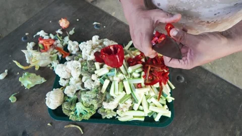 Top-down perspective of vibrant mixed vegetables being cut on a tray Stock Footage 314839387