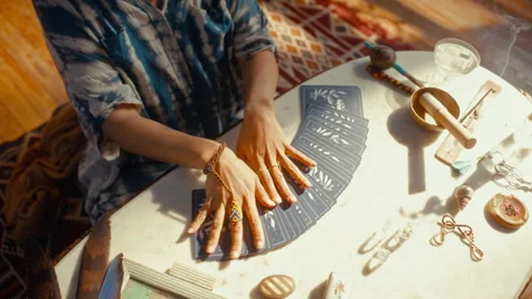 Top Down of Physic Reader Fanning out Tarot Cards on Sunlit Table Vidéo 347631690